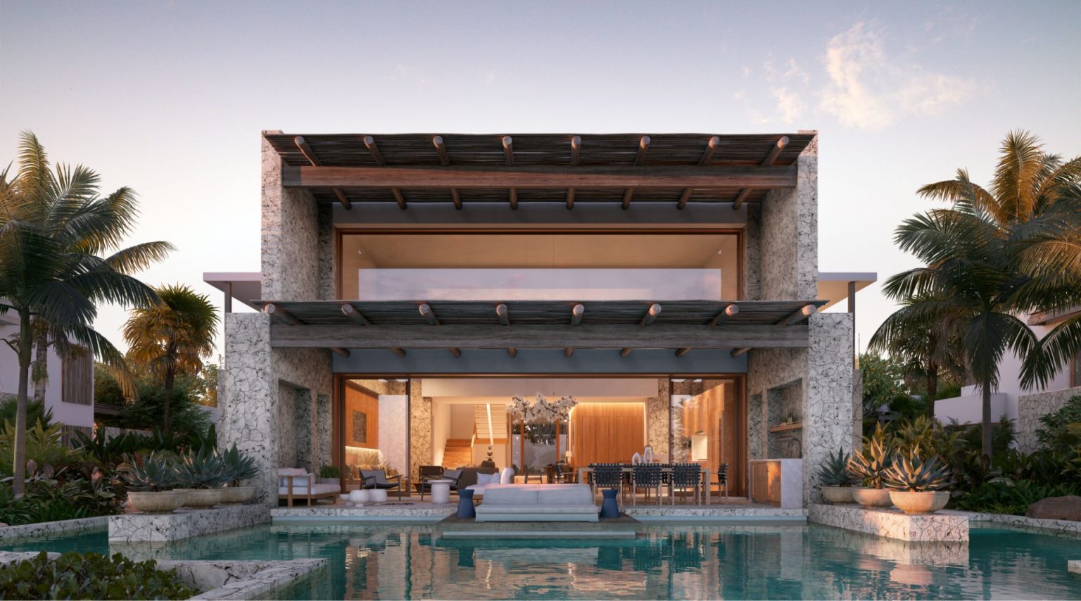 The Strand Turks and Caicos - exterior view of Luxury Residences at sunset with modern, natural stone pool, seating area and lighted interior