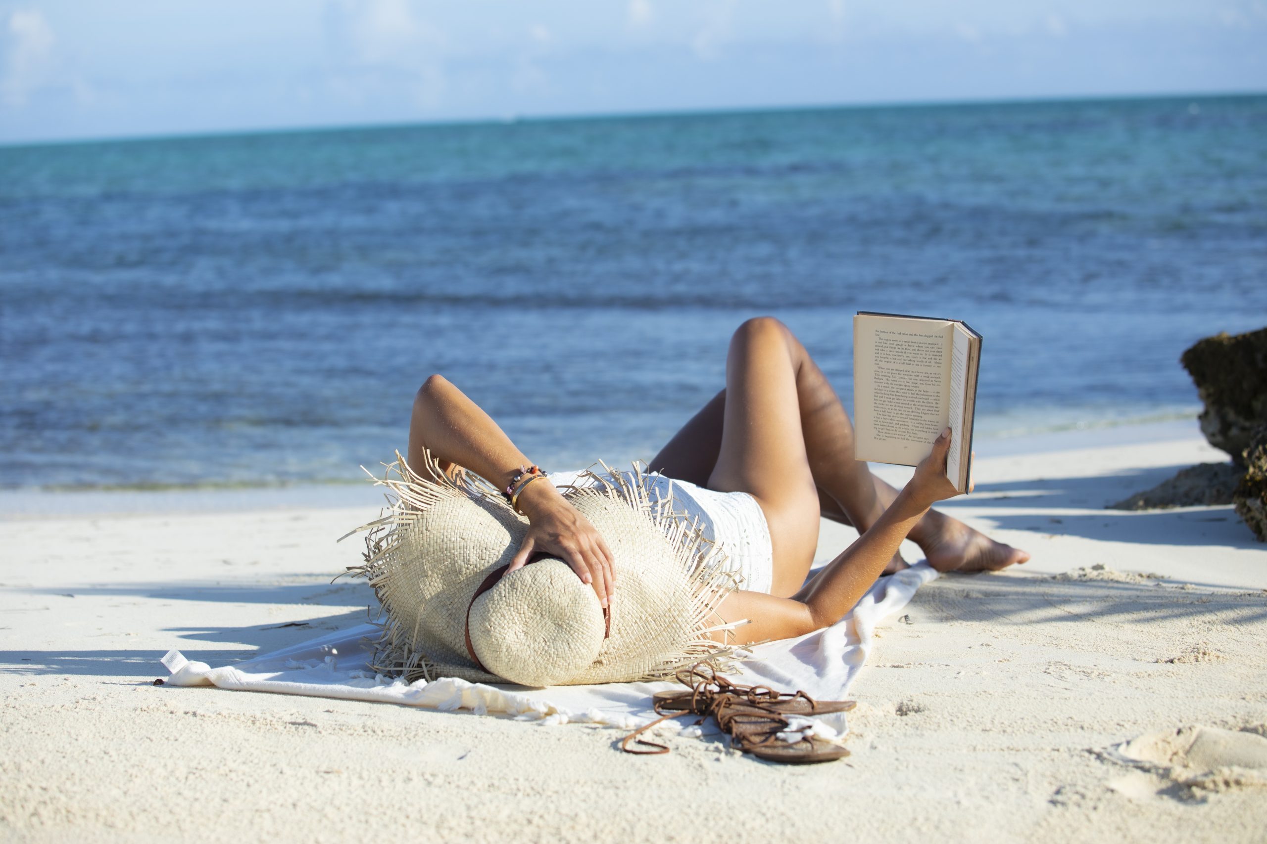 Woman (a mom) reading book on beach