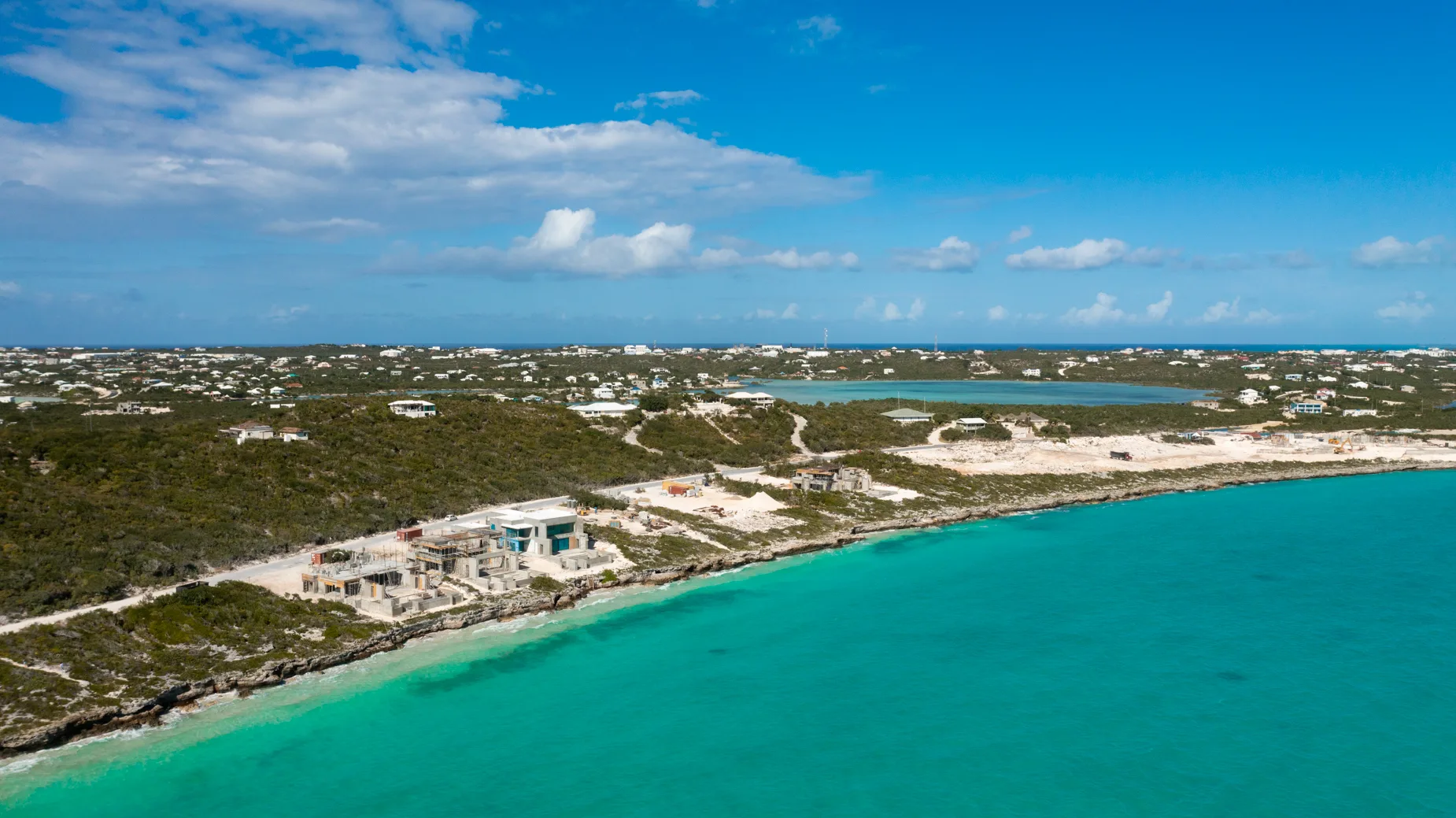 wide shot of shoreline and Coast of Cooper Jack Bay depicting The Strand's Luxury Residences making incredible strides