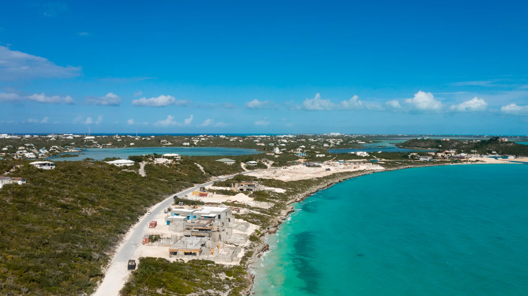 The Strand construction progress behind crystal azure waters at Cooper Jack Bay