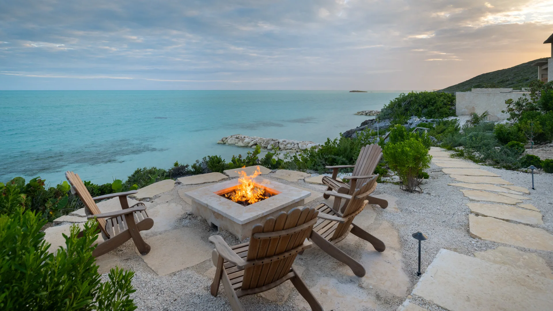 Chairs around a fire pit overlooking Cooper Jack Bay
